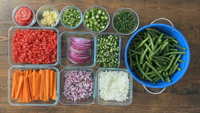 Neatly arranged chopped vegetables and green beans displayed in containers showcasing knolled organization and order.