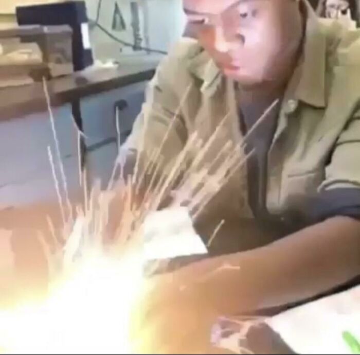 Person focused on welding work with bright sparks flying, capturing one of the frozen frames in action.