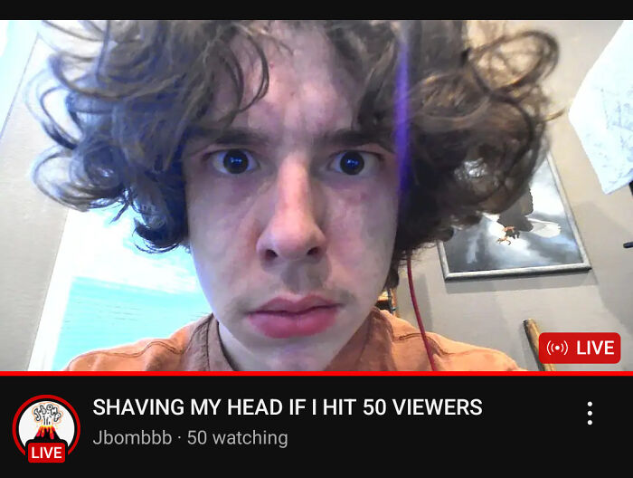 Close-up of a young man with curly hair in a live stream, capturing a frozen frame before an action happens.