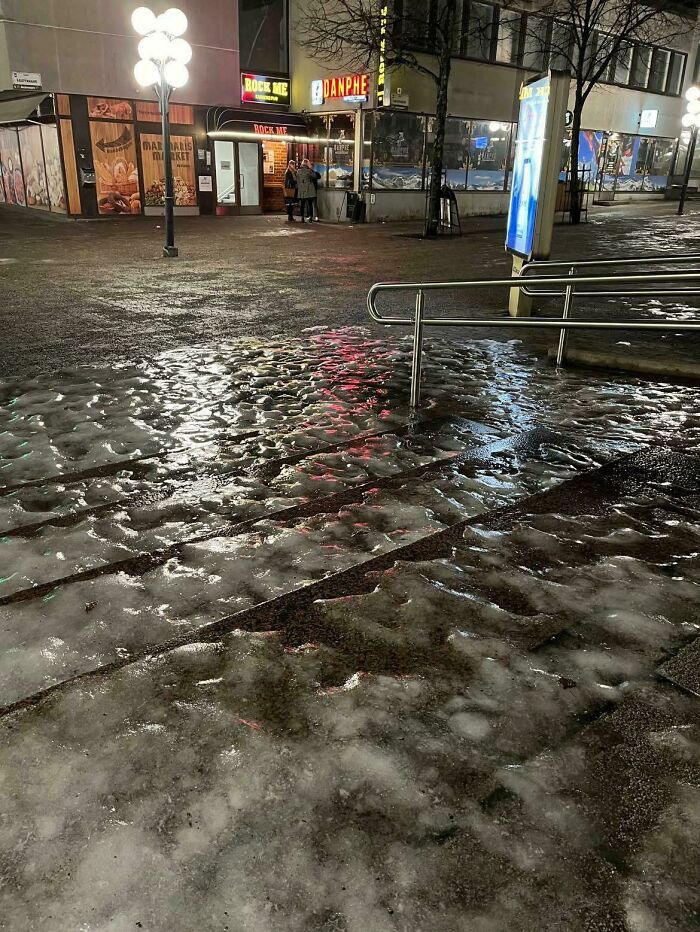 Icy stairs with uneven surfaces and a metal handrail near urban nightlife area, showing Airbnb insanity safety hazard risk.