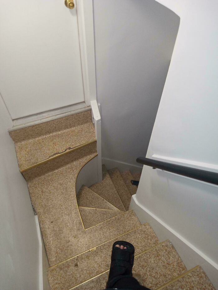 Steep and narrow indoor stairs with a curved landing, highlighting a challenging Airbnb staircase needing insurance caution.