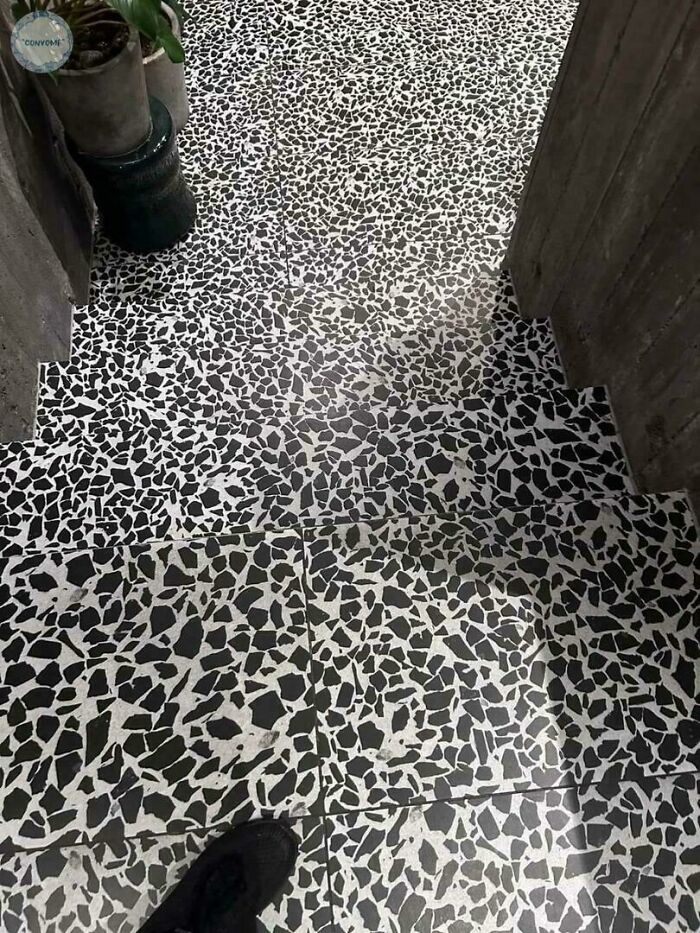 Steep terrazzo stairs with black and white speckled pattern, highlighting Airbnb insanity and the need for insurance.