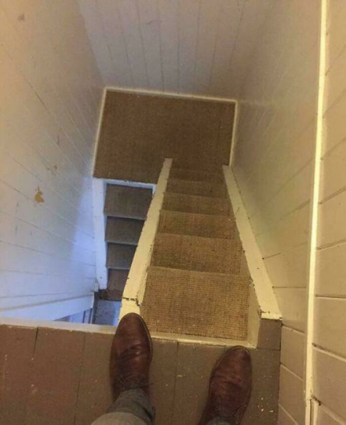 View looking down a narrow, steep stairway in an Airbnb rental, highlighting the need for Airbnb insurance protection.