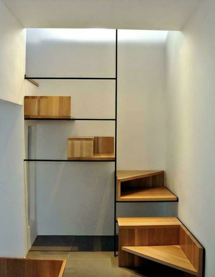 Steep wooden stairs in a narrow modern Airbnb space showing a challenging design that highlights Airbnb stairs insurance needs.