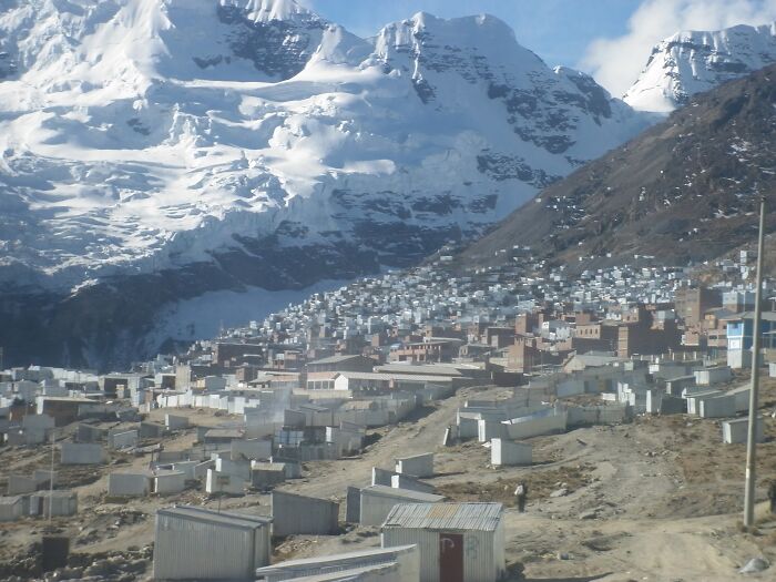 Remote mountain village nestled below snow-covered peaks, showcasing one of the mind-blowing remote locations in the world.