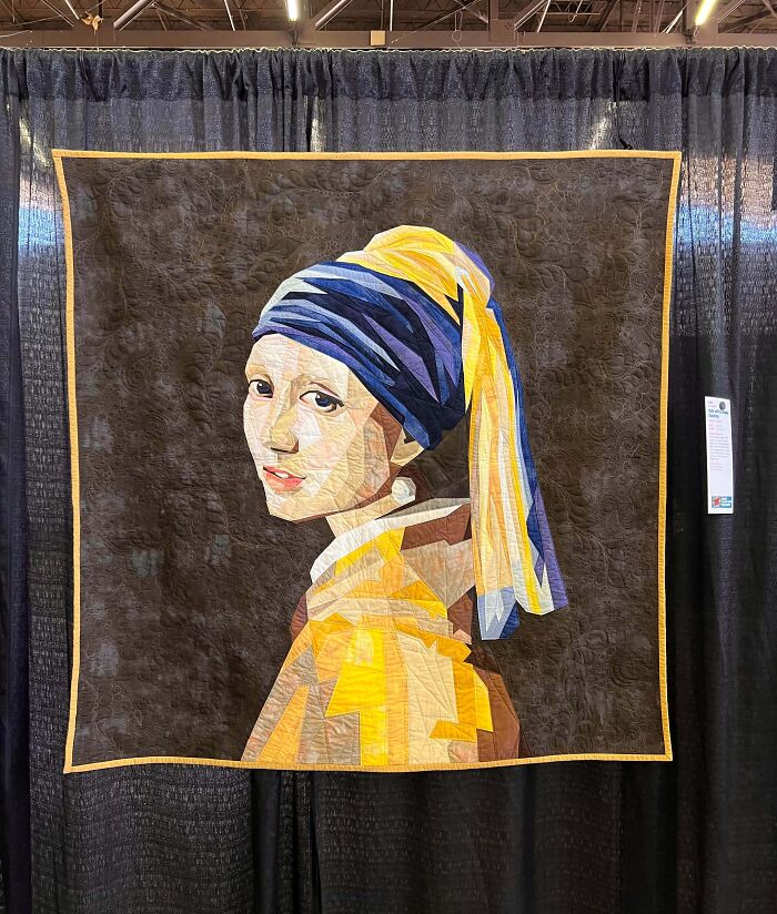 Quilt art of a creative person’s cool project inspired by the Girl with a Pearl Earring, displayed at an exhibit.