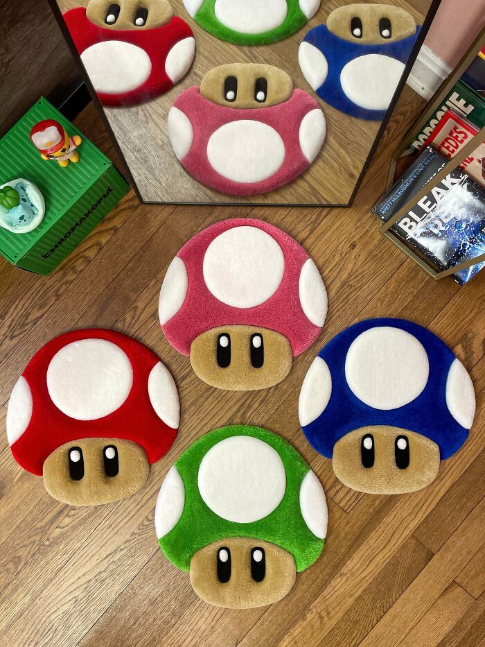 Colorful mushroom cushions inspired by creative people’s cool projects arranged on a wooden floor near a mirror and books.