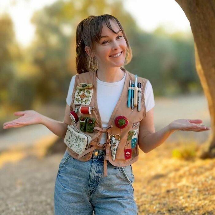 Young creative person outdoors wearing a vest filled with art and craft tools, showcasing imaginative projects and ideas.