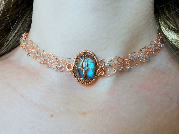 Intricate wire-wrapped choker with a glowing blue stone and tree design, showcasing creative people’s cool projects.