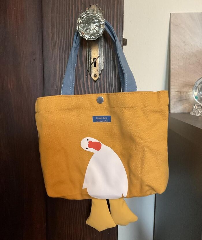 Yellow canvas tote bag with blue handles featuring a white duck design, a unique gift idea for impossible to shop for people.