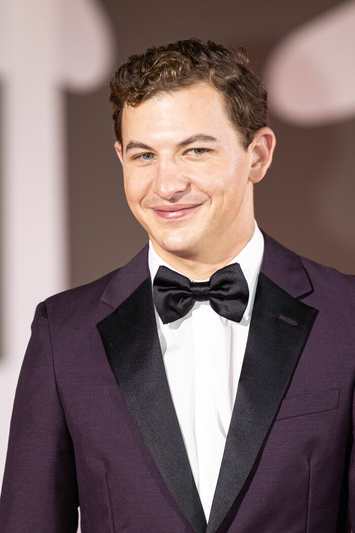 Tye Sheridan in a dark suit with black bow tie, smiling at a formal event, highlighting his bio and career.