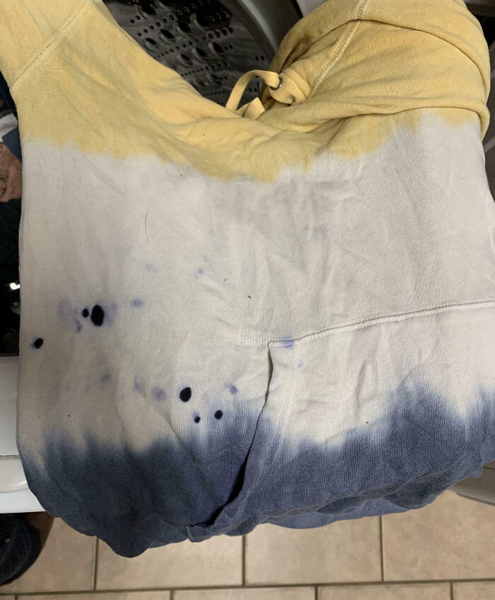 Hoodie stained with ink spots and discoloration, showing a frustrating family moment shared online for venting.