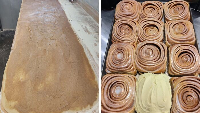 Freshly baked cinnamon rolls arranged in a tray with one roll topped with creamy frosting, showcasing gorgeous baked goods.