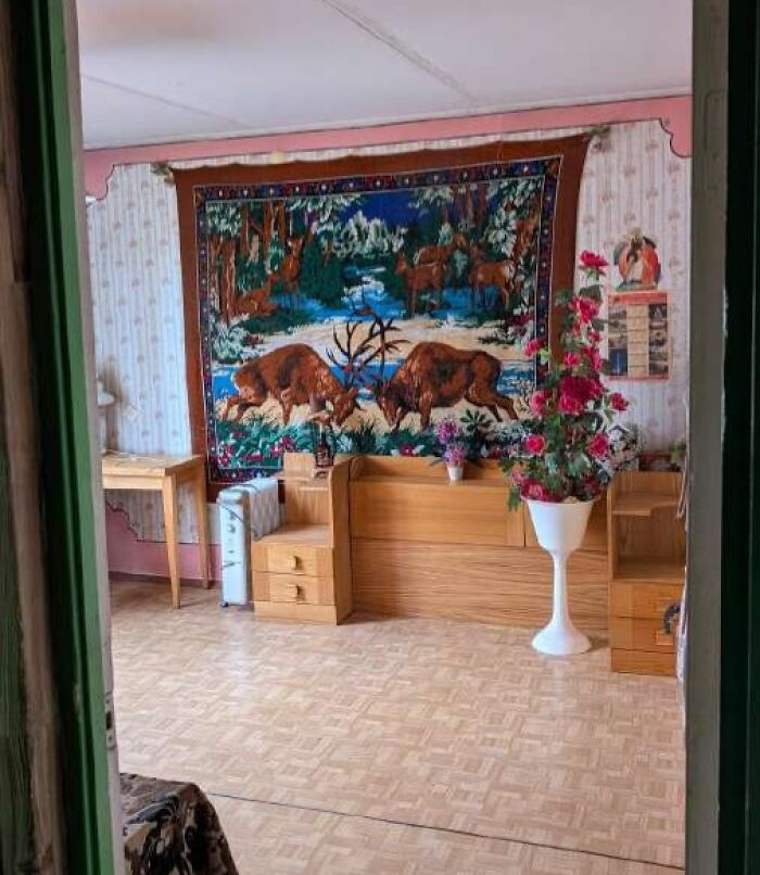 Living room with wooden furniture and a wild real estate listing featuring a large decorative deer tapestry on the wall.