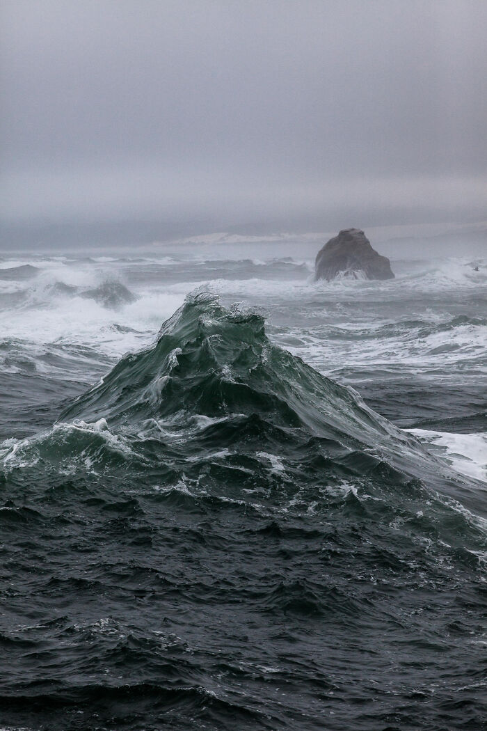 Rough ocean waves crashing under a gray sky, showing our world from a completely different perspective.