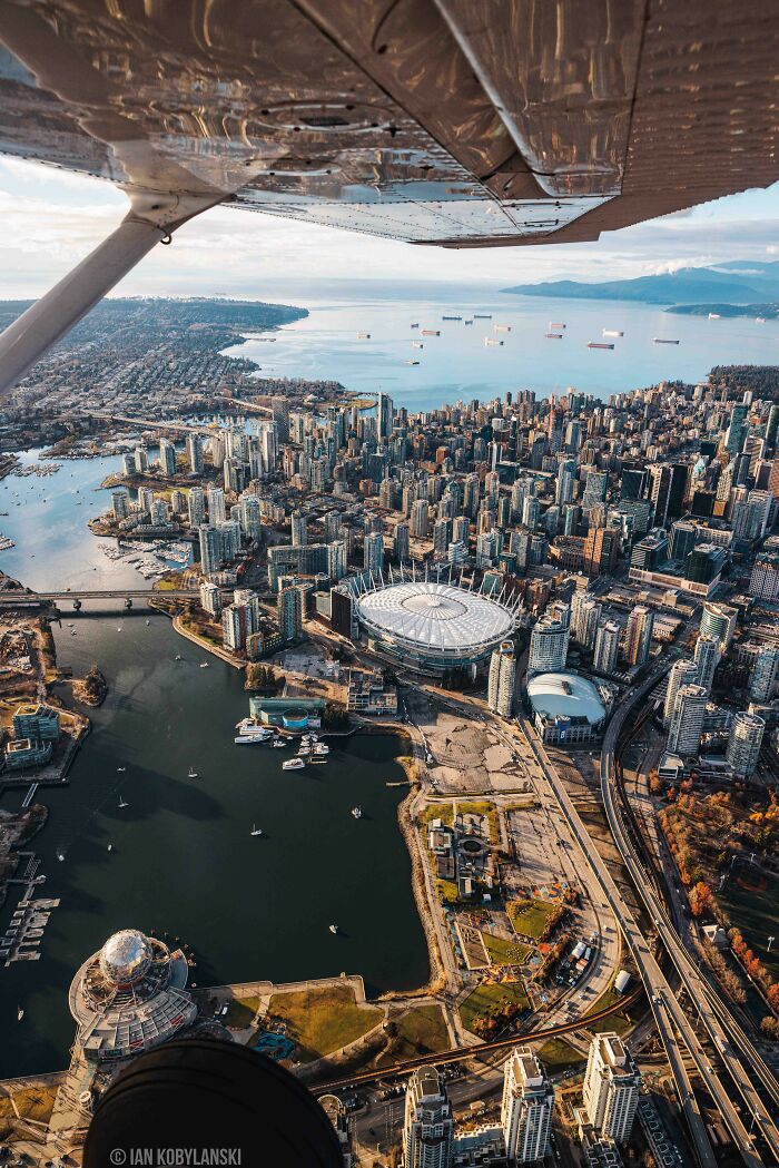 Aerial view of a cityscape with waterfront, stadium, and ships in the bay showing our world from a different perspective.