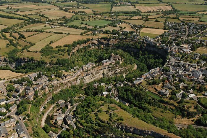 Aerial view of a village surrounded by fields and cliffs, showing our world from a different perspective.
