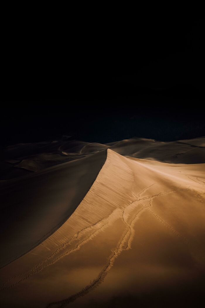 Aerial view of sand dunes with footprints illustrating a unique perspective of our world in natural landscapes.