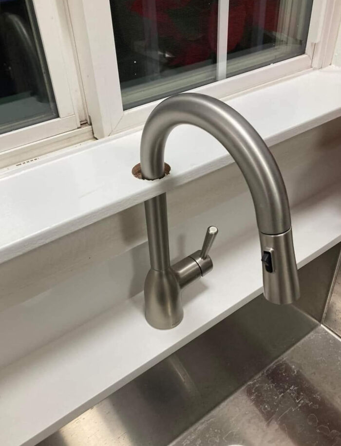 Kitchen faucet installed through the window ledge with poor workmanship showing a funny example of people not even trying.