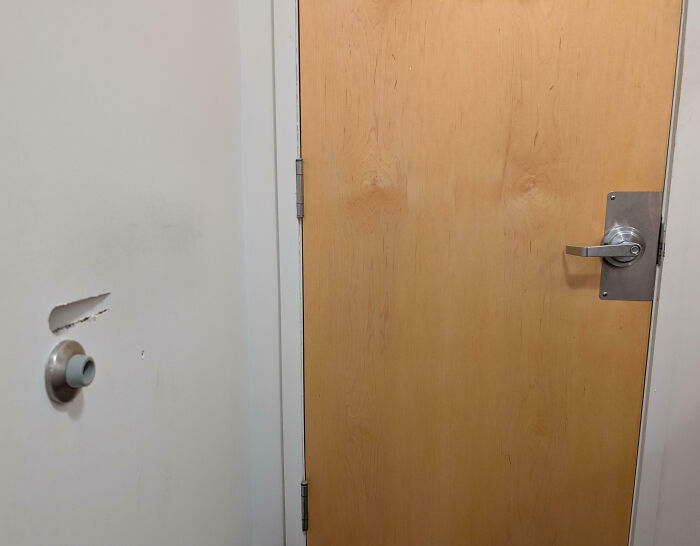 Door with a broken handle next to a missing k**b showing a funny example of people not even trying repair job.
