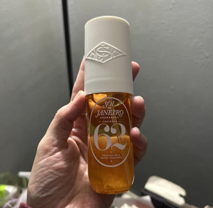 Hand holding Sol de Janeiro scented perfume mist, a popular gift idea for holiday shopping satisfaction.