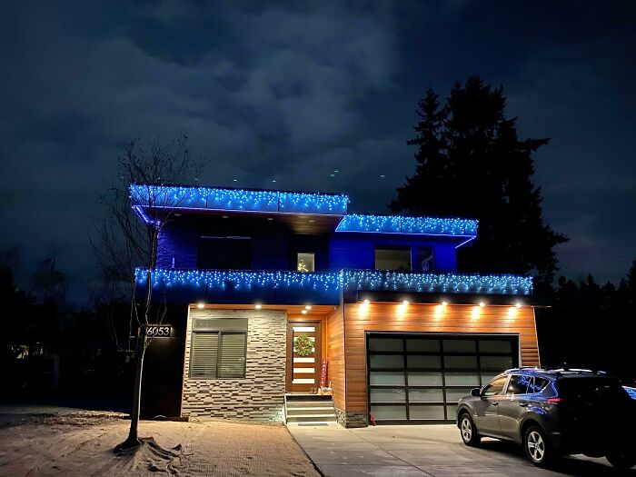Modern house decorated with blue lights at night, showcasing how people turned their dreams into reality and inspired others.