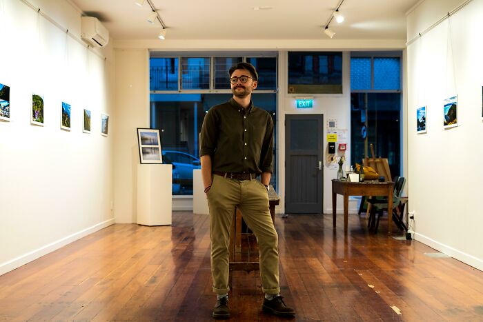 Man standing confidently in an art gallery, showcasing creativity and inspiring others to turn dreams into reality.