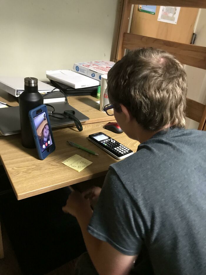 Person video calling their sibling at a desk with study materials, showing a moment of sibling gratitude and connection.