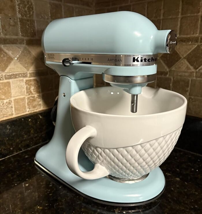 Light blue KitchenAid stand mixer with white textured mixing bowl on kitchen counter, Black Friday deals essential kitchen appliance.