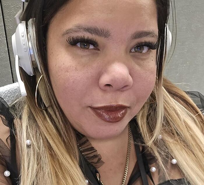 Close-up of a woman wearing headphones and stylish makeup, representing Black Friday deals and wishlist ideas.