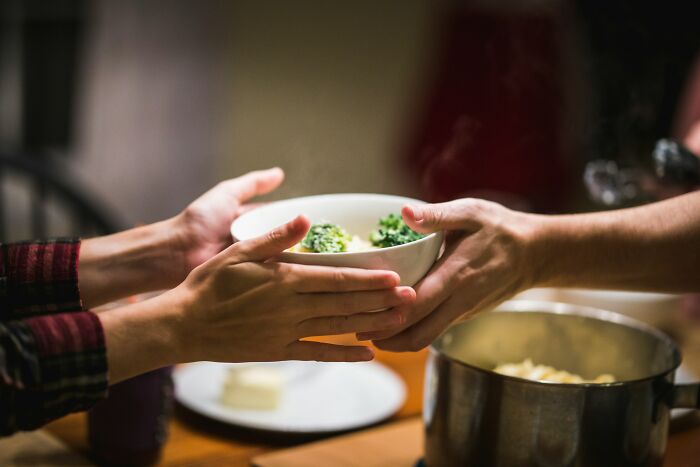 Two people exchanging a bowl of food, illustrating a moment related to testing trust in a relationship. Two people exchanging a bowl of food, illustrating a moment related to testing trust in a relationship.