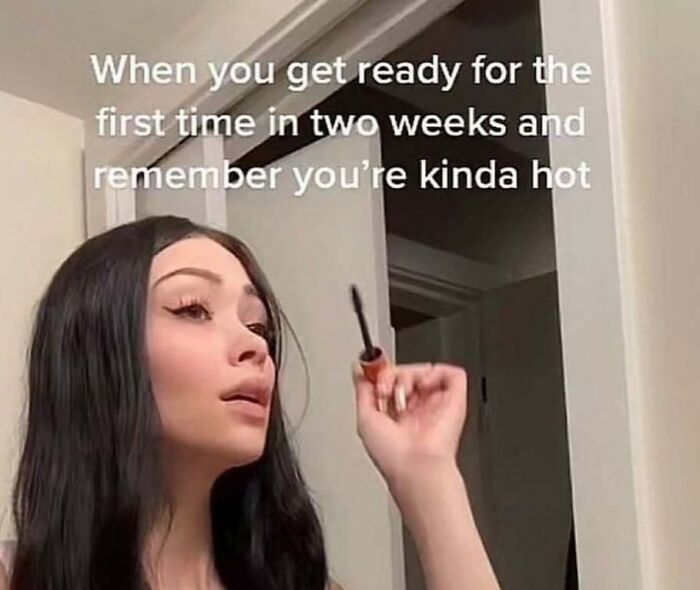 Woman applying mascara in front of a mirror, relating to makeup, fashion, and the diva life humor meme.