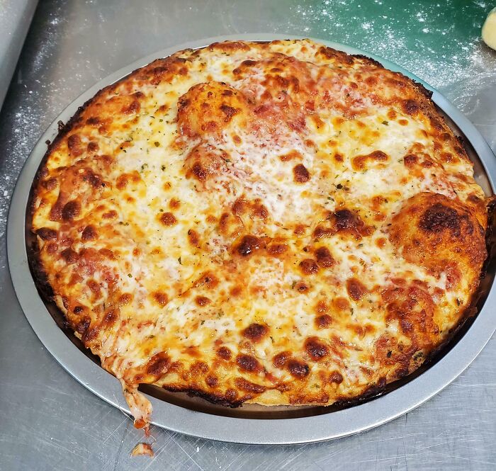 Homemade cheese pizza with golden melted cheese showcasing a dream turned into reality by pizza lovers.