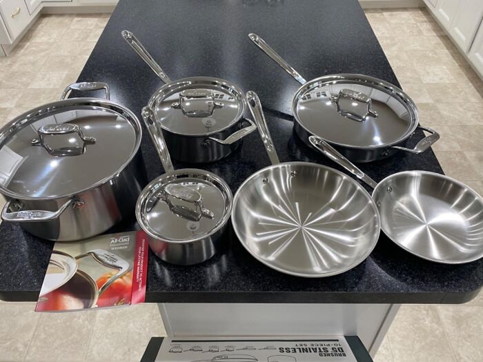 Stainless steel cookware set displayed on kitchen counter featuring pots, pans, and lids for Black Friday week deals.