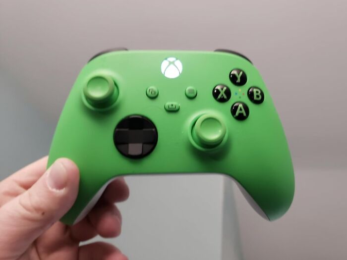 Green Xbox controller held in hand, highlighting Black Friday week hot deals on gaming accessories and electronics.