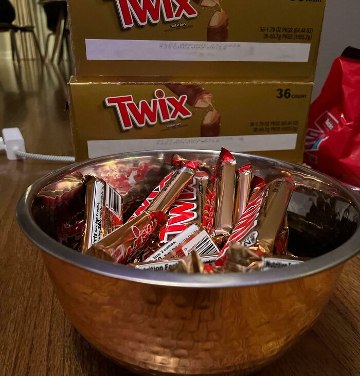 Bowl filled with Twix candy bars with boxes in the background, symbolizing people turning dreams into reality.