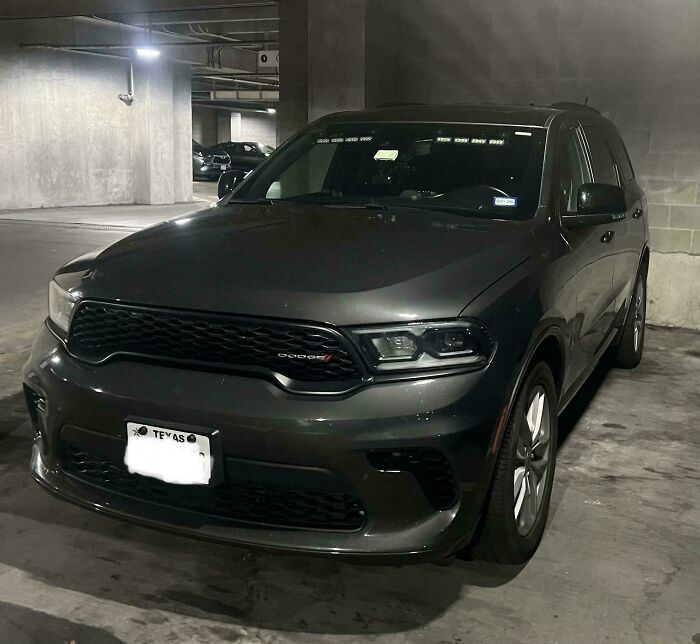 Dark gray Dodge SUV parked in a dimly lit garage, an example of cars people tried to make cooler with unusual modifications.