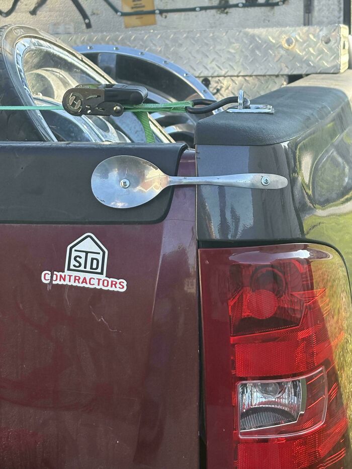 Car with a spoon attached as a side mirror, an example of stupidity on wheels in failed car modifications.