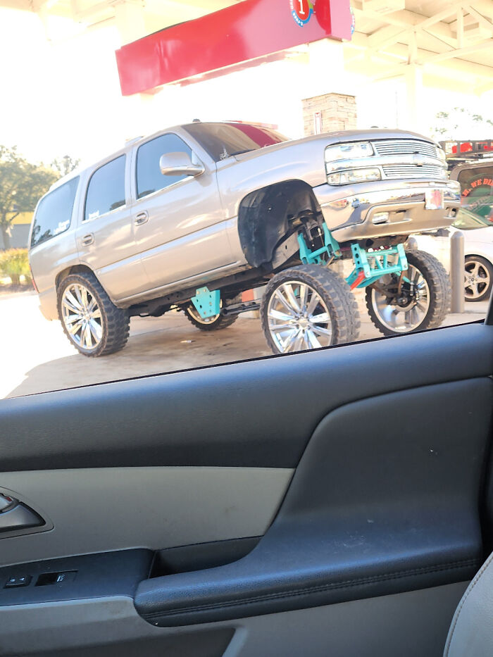 Silver SUV with oversized wheels and lifted suspension modification, showcasing a failed attempt to make the car cooler on the street.