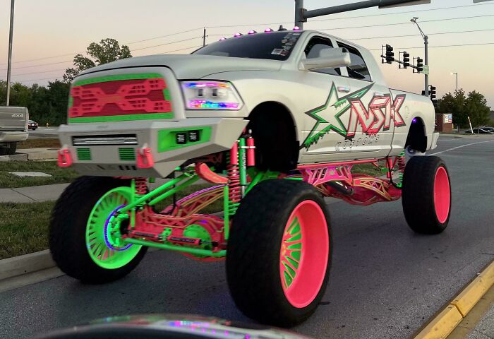 Lifted truck with neon green and pink custom parts, an attempt to make a car cooler that resulted in stupidity on wheels.