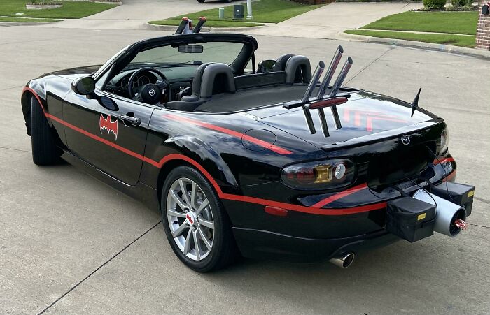 Black Mazda convertible with failed car customization featuring an awkward Batman theme and bizarre rear attachments.