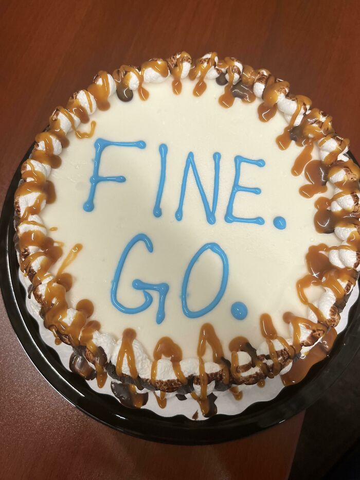 Cake with caramel drizzle and blue icing spelling fine go representing employees who walked out with jokes and pranks.