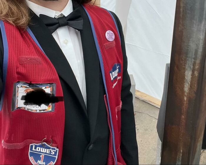 Employee wearing a Lowe's vest over a tuxedo jacket, showcasing a creative and humorous work prank outfit.