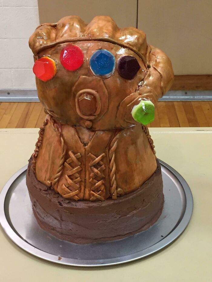 Sculpted cake of an Infinity Gauntlet with colorful stones, showcasing sibling gratitude and creative celebration.