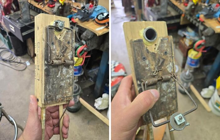 Handheld homemade contraption made from an old mousetrap and wood in a cluttered workshop, redneck engineer creation.