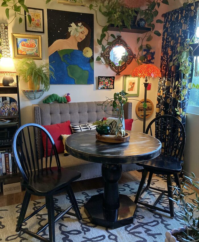 Cozy dining nook with indoor plants, colorful artwork, and rustic furniture inspiring people to turn dreams into reality.