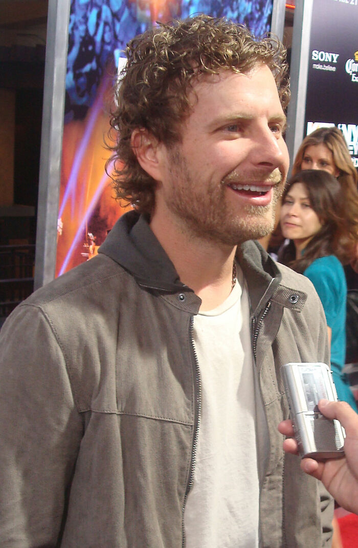 Dierks Bentley smiling in a casual jacket during an interview at a music event.
