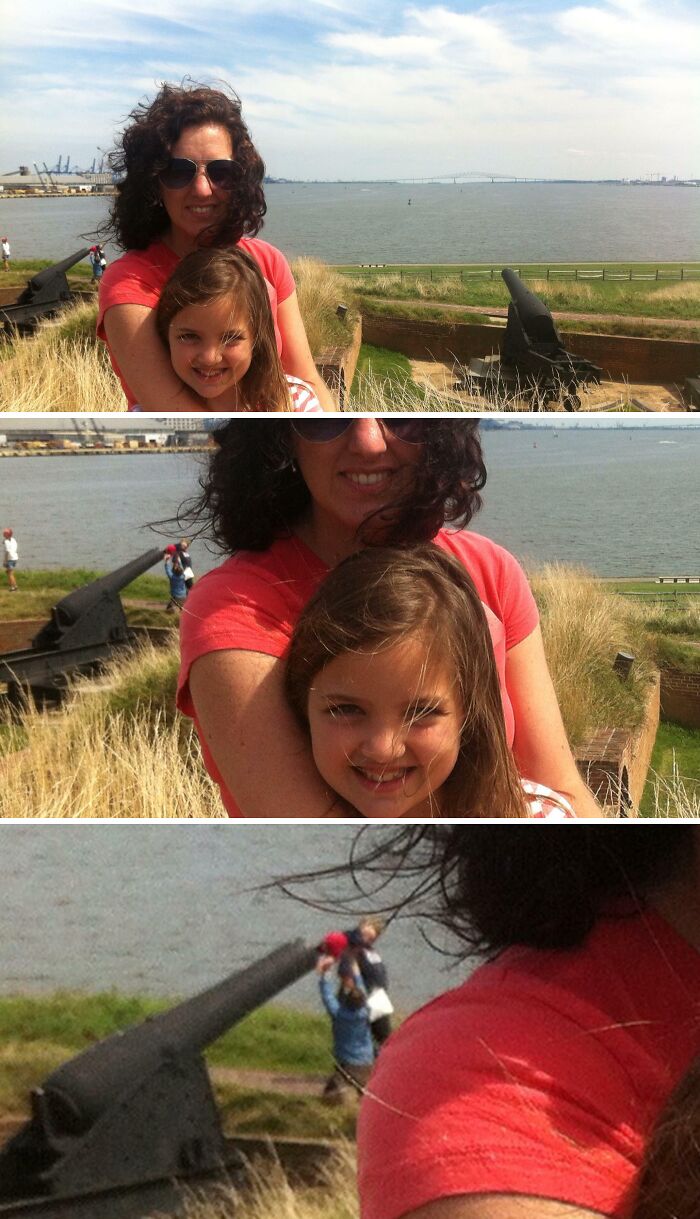 Mother and daughter posing near old cannons by the water with an epic photobomb that stole the show in the background.