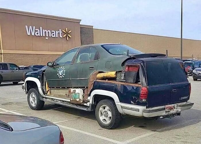 Modified car with mismatched parts and poor design parked outside Walmart, an example of stupidity on wheels.