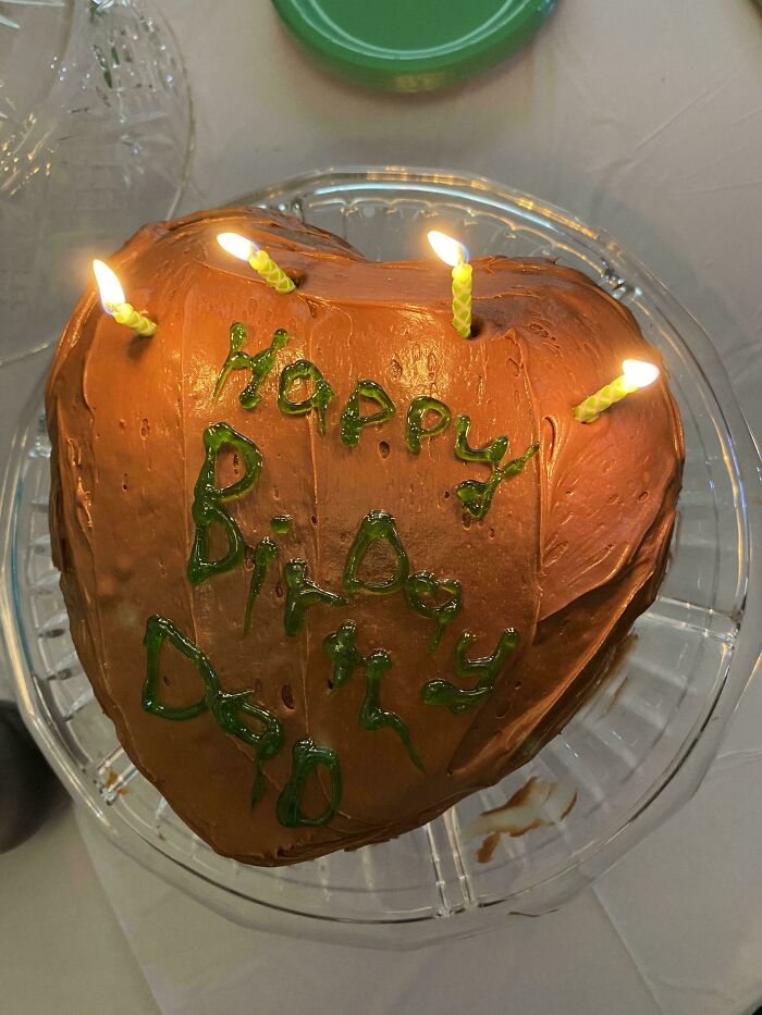 Heart-shaped birthday cake with lit candles and homemade frosting, showcasing wholesome internet moments and kindness.